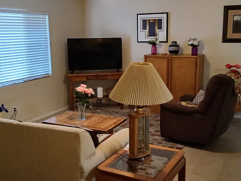 The cozy living room features a comfortable couch, a soft recliner, and a smart TV.