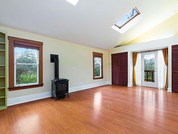 The large living room has space for reading nooks, media corners and you could even have an office here. Stay cozy with the gas stove! There are 2 large storage closets at the end of the room, vaulted ceilings, skylights and a door out to the large deck.