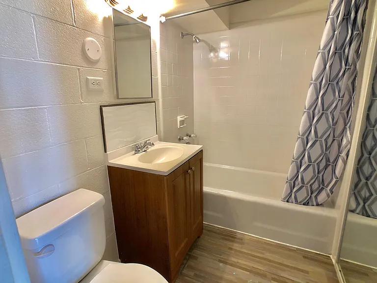 Newly glazed tub, new cabinet, sink and new laminate flooring