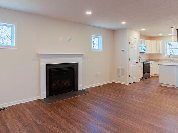 Gas fireplace with flanking square windows - adjacent to kitchen -vinyl plank flooring