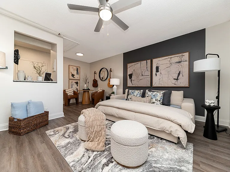 Spacious open living & sleeping area with hardwood-style flooring & ceiling fan