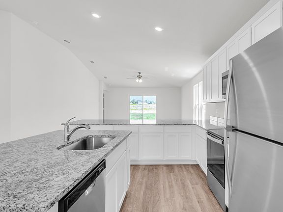 Stunning kitchen with white cabinets, stainless steel appliances and granite countertops
