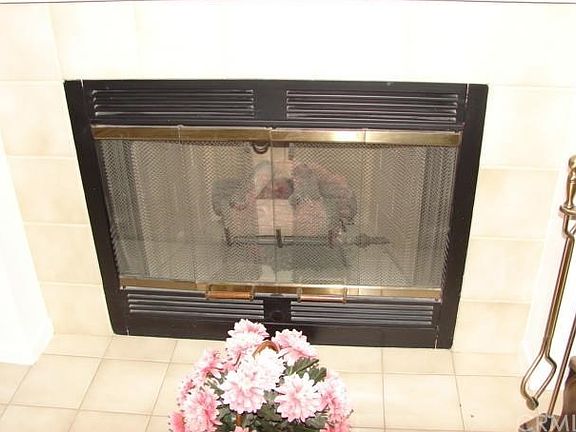 LOVELY TILED GAS LOG FIREPLACE IN LIVING ROOM