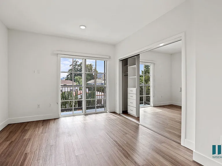 Bedroom with Mirrored Closet , Patio, and Vinyl Flooring