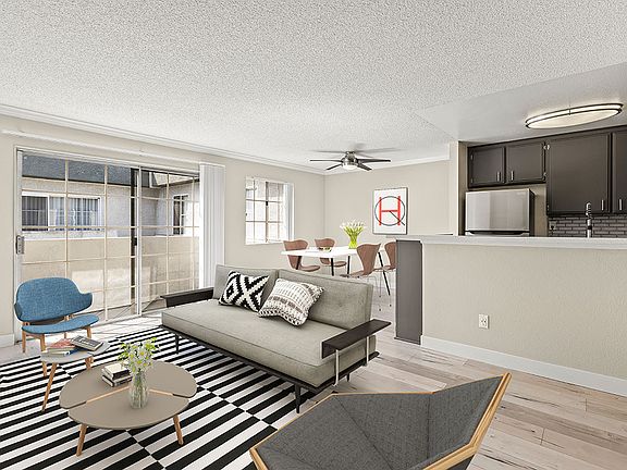 Living room with hardwood floor and view of dining room and kitchen area.