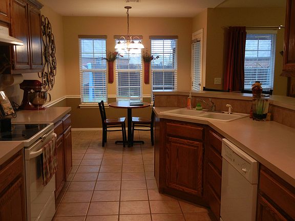 Large social kitchen opens to living, nook, all tiled