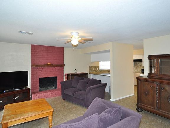 Spacious family room with brick fireplace and breakfast bar open to kitchen