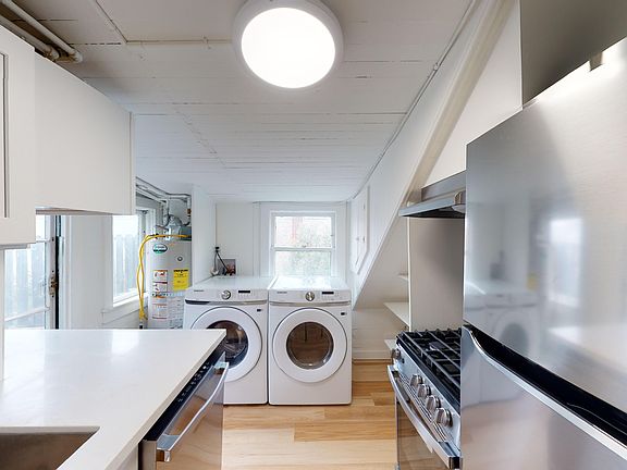 Kitchen with cabinets, refrigerator, stove, range hood, and sink