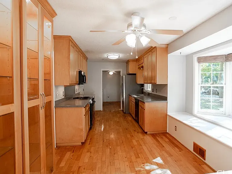 Spacious kitchen with solid wood cabinets, hardwood floors, built-in display cabinets. Electric range, microwave, dishwasher.