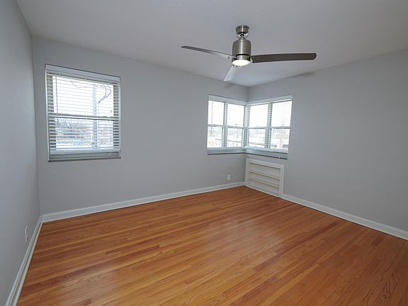 Large bedroom with corner windows and shelving