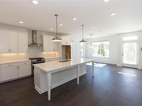Gorgeous designer kitchen with white cabinets and large island. Photo of a previously built home and