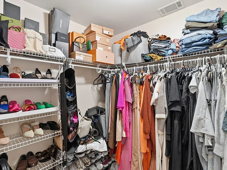 Walk-in closet with custom shelving and ample storage space