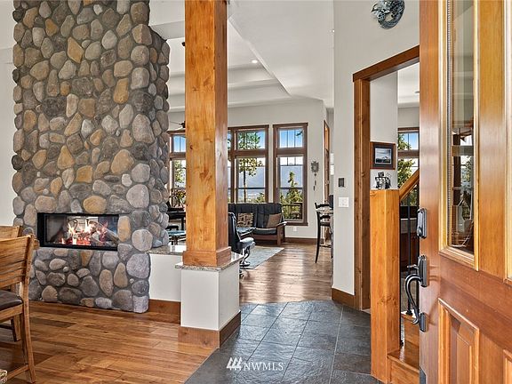 This is what welcomes you inside! Soaring ceilings, hard surfaced floors, gorgeous wood wrapped beams, & floor to ceiling fireplace. Just gorgeous!