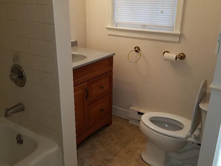 Bathroom with shelf above toilet for extra storage.