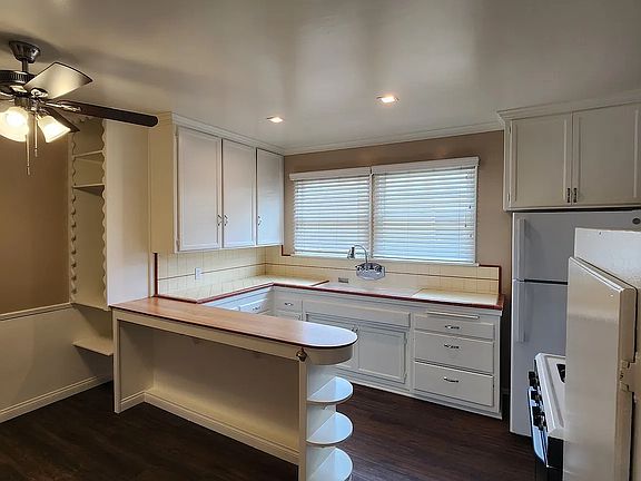 View of Kitchen with Island eating area canned lighting, crown molding, refrigerator, and gas stove