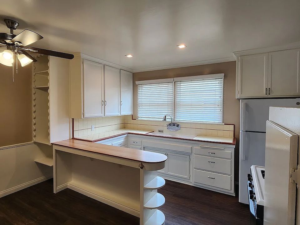 View of Kitchen with Island eating area canned lighting, crown molding, refrigerator, and gas stove