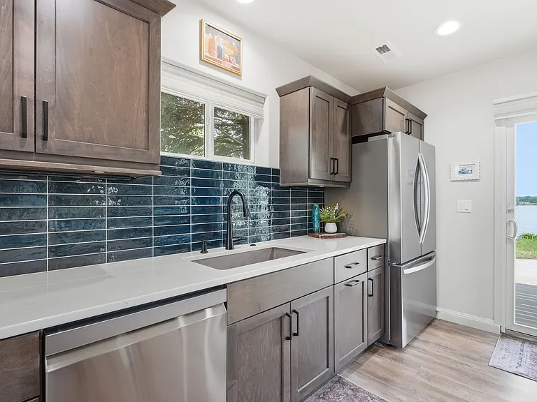 Full kitchen on main level w/ SS appliances, quartz countertops, tile backsplash & granite composite sink.