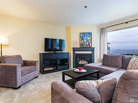 Spacious living room with a cozy fireplace for dreary days.