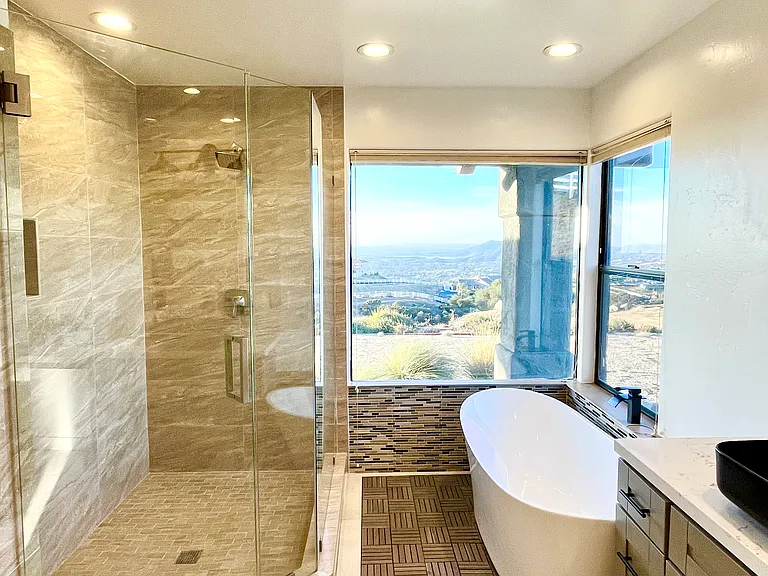 Primary bathroom contains a spacious, modern shower, a soaking tub, his and hers sinks, separate his and hers walki-in closets, and a separate toilet room