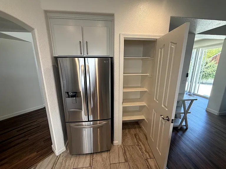 Walk-in pantry with built-in shelving for convenient kitchen storage.
