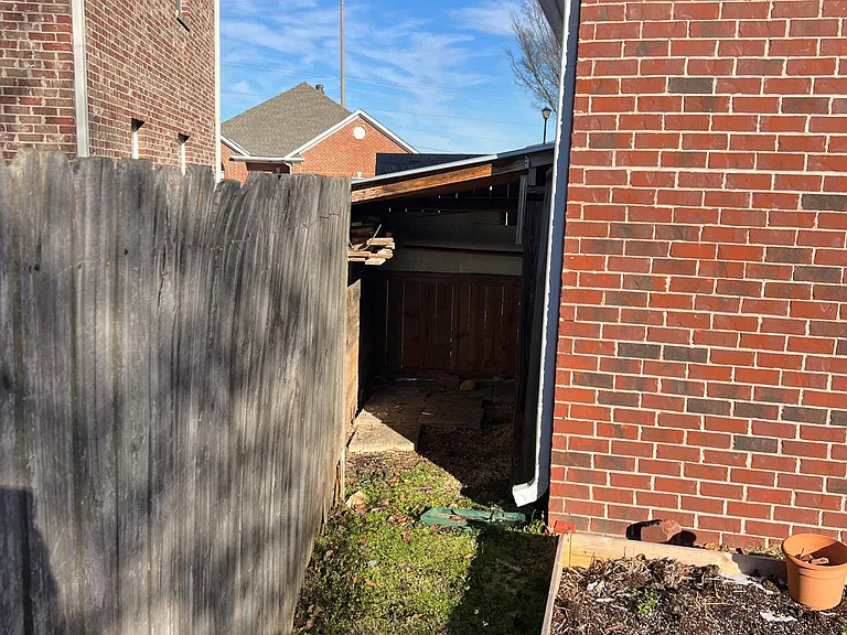 Left side of backyard with covered storage area.