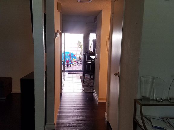 Looking down the short hallway to the Kitchen from the front of the home. Powder room is on the right side of the hallway just a