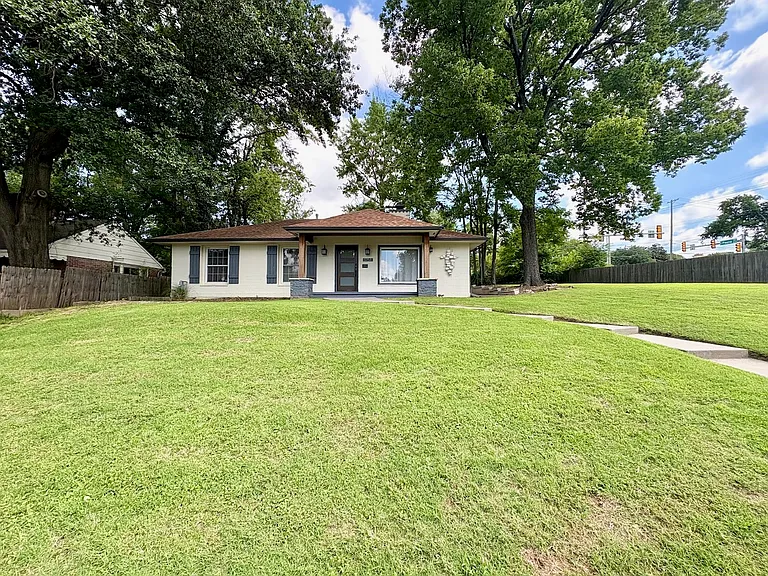 View of front of house and double lot with walkway and large yard