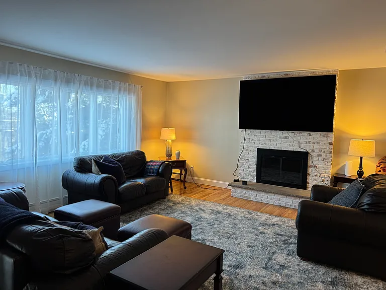 This is one of two living rooms. Both have wall mounted TVs, furniture and working fireplaces. The lower floor living room has a pool table.