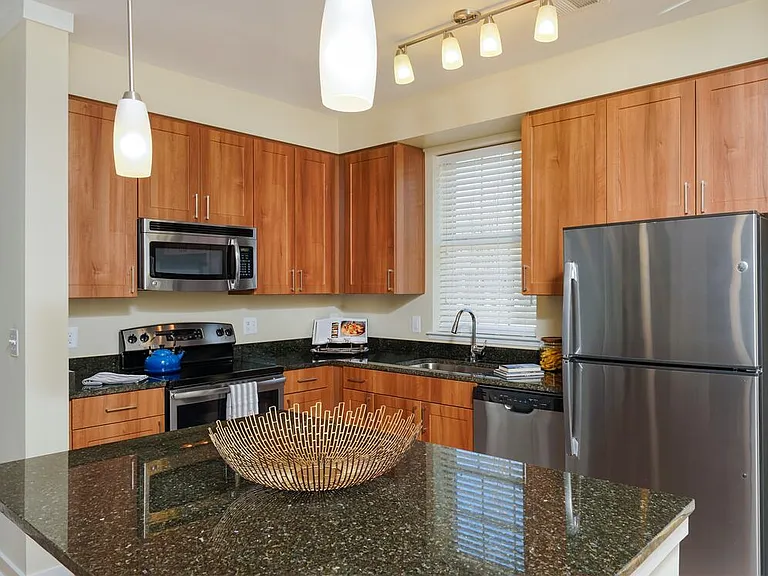 Classic Package I kitchen with stainless steel appliances, oak cabinetry, black granite countertops, and hard surface flooring