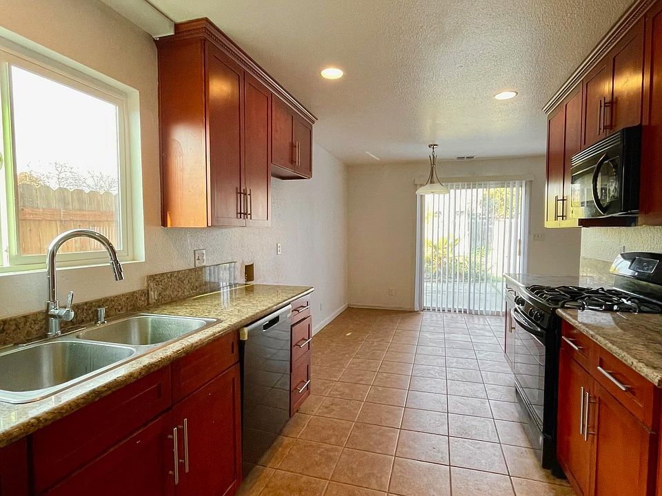 Kitchen with granite slab counter and cherry cabinets
