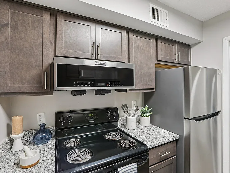 Kitchen with granite counters, black appliances, and modern cabinetry