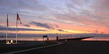 This is what makes our town so desirable. This is a morning sunrise over our harbor, lighthouse, fishing pier and beachfront.