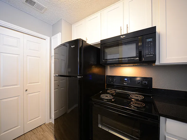 The Trellis at Lake Highlands kitchen area with refrigerator, stove, and cabinets
