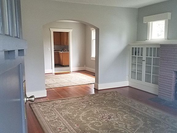 Living room and dining room open floor plan - charming old world arched entries and built in bookcases.