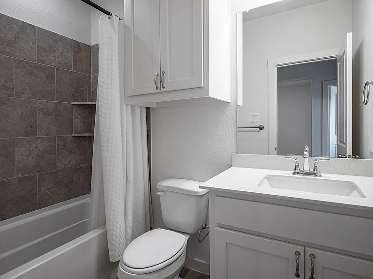 Full bathroom with vanity, toilet, and shower / bath combo.