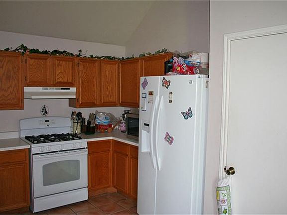 Another view of the kitchen with it's nice appliances and refrigerator