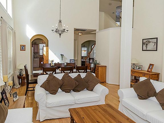 Step into beautiful entertaining spaces in this formal living and formal dining room with soaring ceilings and hardwood flooring.