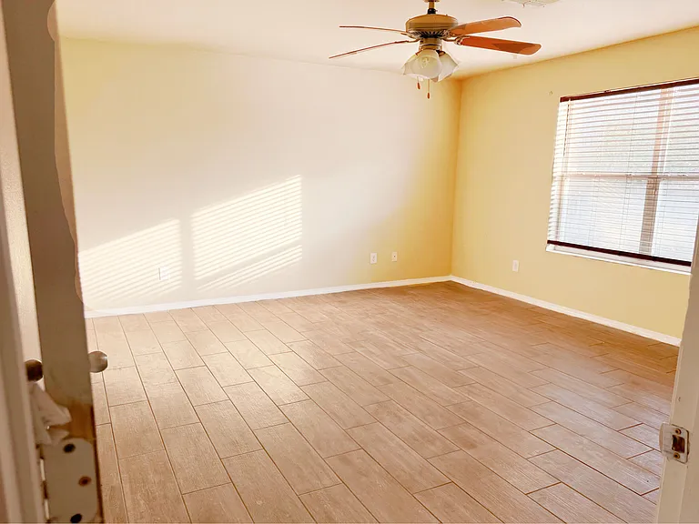 Master bedroom with brand new ceramic wood tile flooring & ceiling fan/light.