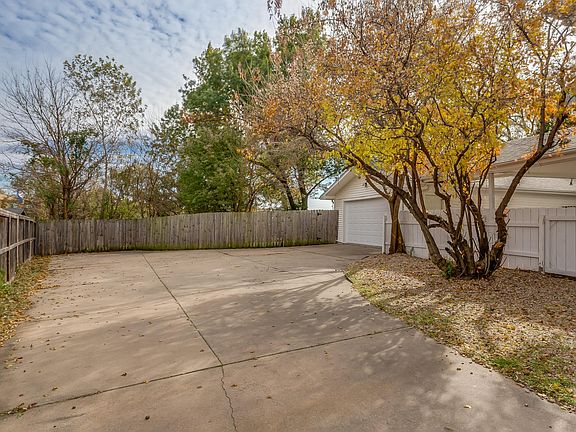 Over-sized side load 2 car detached garage w/covered breezeway and extra deep driveway with wide parking area.