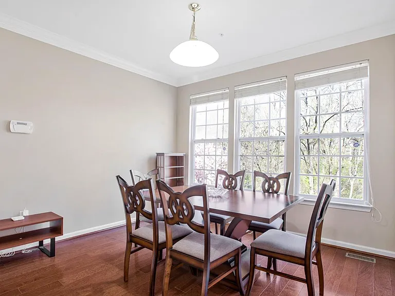 The bay window brings the outdoors in, filling the dining room with natural light and peaceful tree-lined views.
