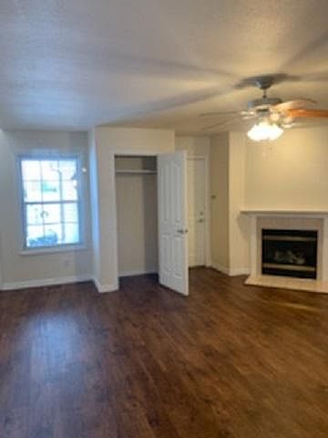 Living room with vinyl plank flooring, gas fireplace and entry closet