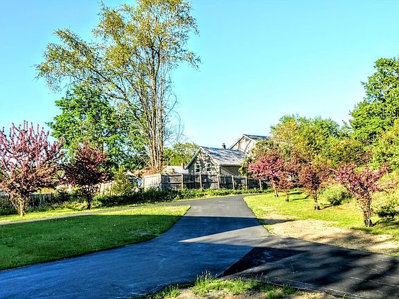 view of front yard from the woods on the south side of property (the house in the distance is next-door)