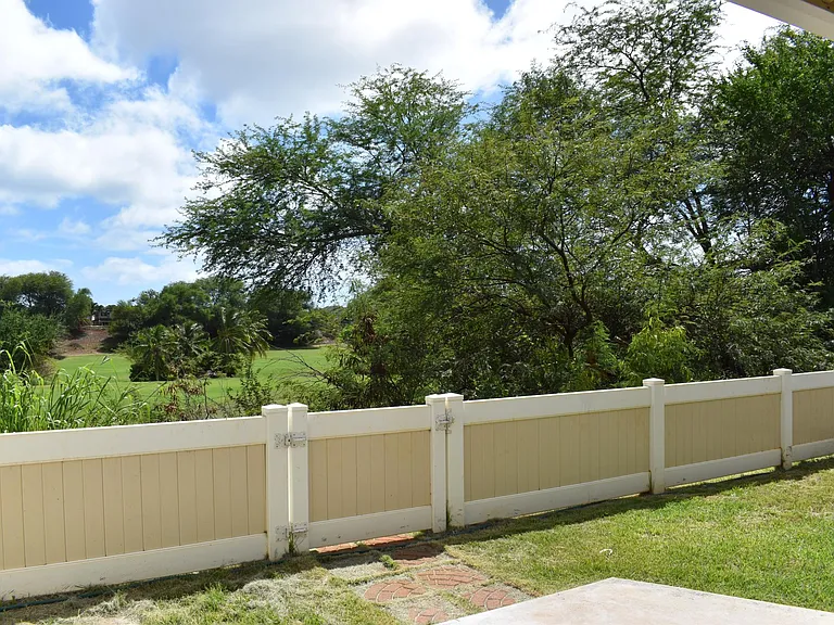 Fenced-in yard with view of golf course
