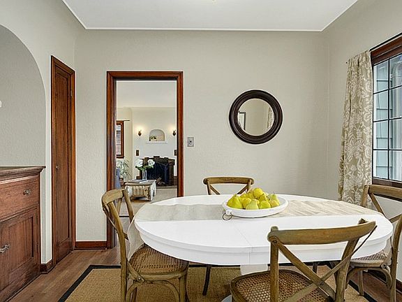 Inviting dining room with attractive built-ins, and a recessed niche, leaded glass windows, coved ceiling, and hardwood floors.