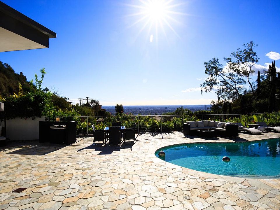 Sunny poolside with a lot of outdoor furniture