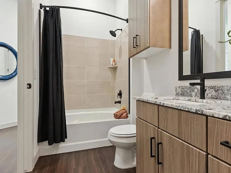 Bathroom with Wood Cabinets, Stone Countertops, and Shower-Tub Combo