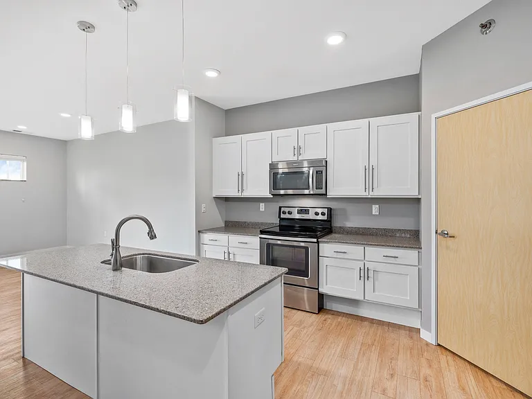 Modern kitchen with sleek countertops, stainless steel appliances, and elegant pendant lighting, perfect for culinary enthusiasts. Modern kitchen with sleek countertops, stainless steel appliances, and elegant pendant lighting, perfect for culinary enthus