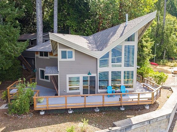 Waterfront view of home showing the extensive Reliaboard composite decking. Perfect for entertaining your guests and taking in the amazing views. Partial view of the One car garage with storage below. 