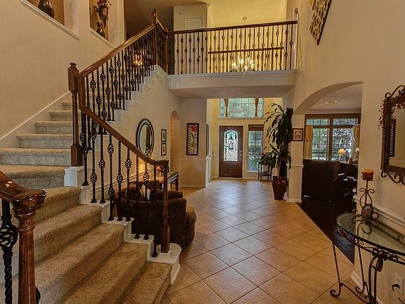 View of the grand entryway and hallway leading from the front door. Just past the FRONT DOOR you will find 2ND MASTER SUITE downstairs.