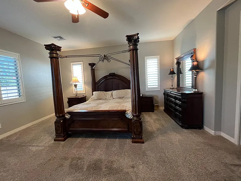 Master bedroom, opposite bed is an entertainment center with TV, there is also a private door to the backyard from this room